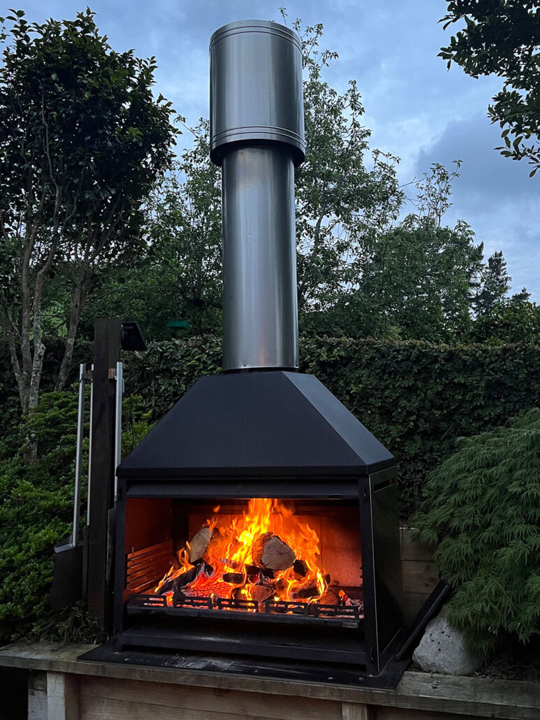 An outdoor fireplace heating a deck area