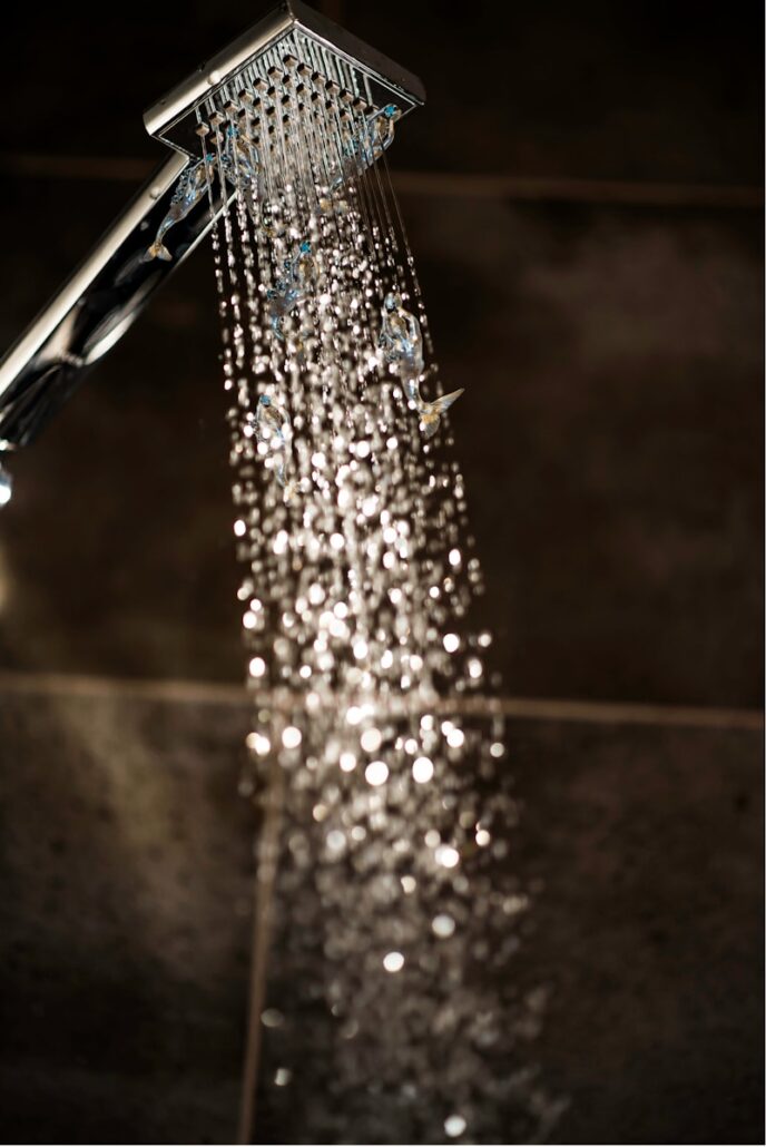 a close up of a shower head with water coming out of it